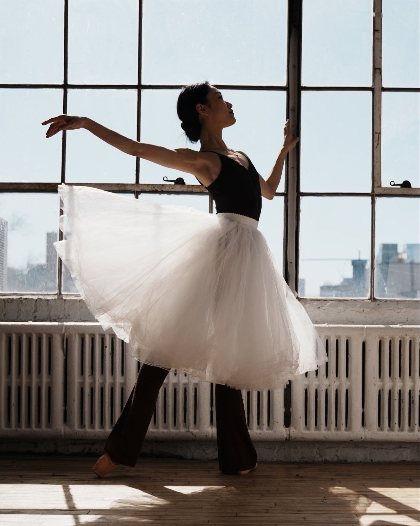 Ballet dancer/soloist Fangqi warming up in studio wearing noisette wool legwarmers and tutu