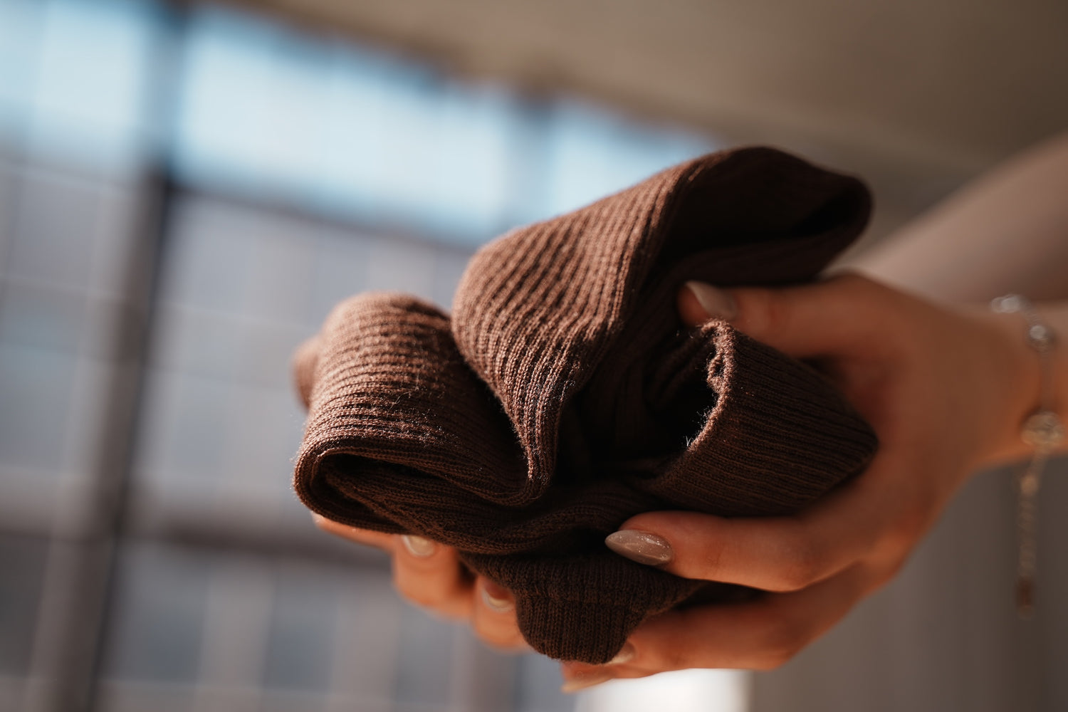 Folded brown wool ballet legwarmers showing softness and knit texture